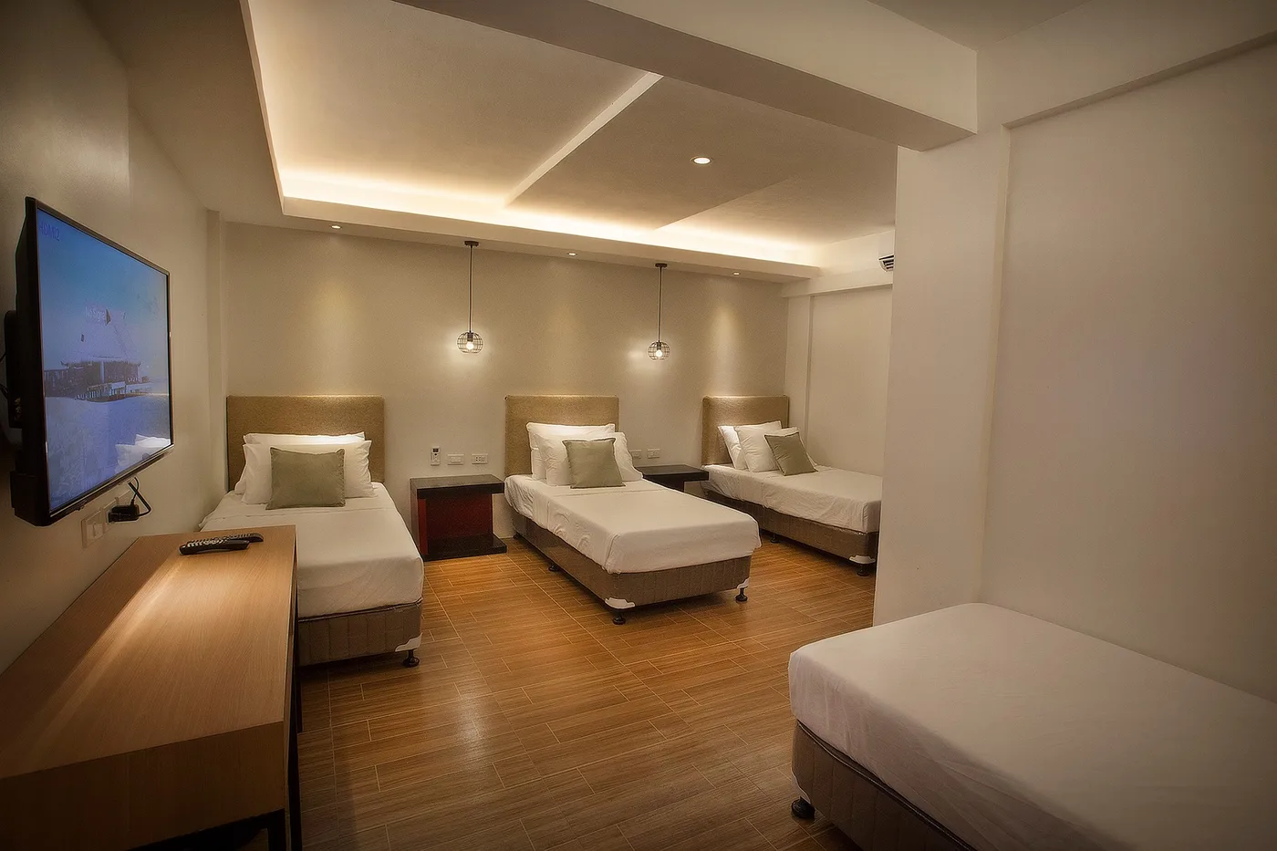 A hotel room with three beds