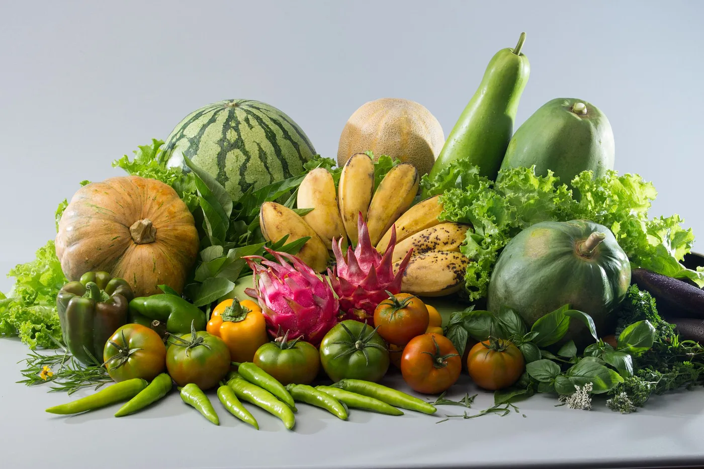 Fresh fruit and vegetables: watermelon, squash, papaya, bananas, dragon fruit, tomatoes, peppers, lettuce and herbs